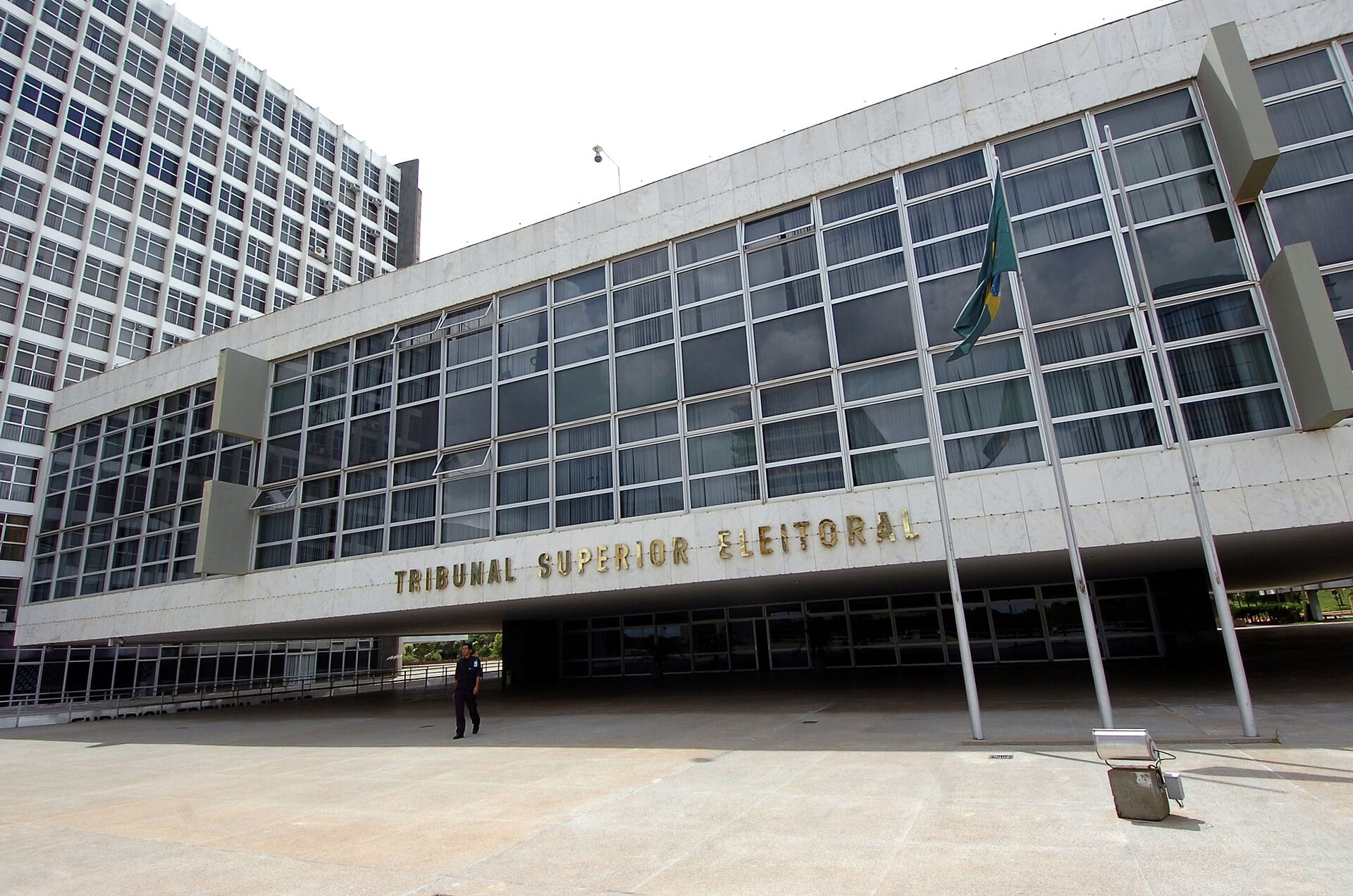 A white modernist building with large glass windows, a Brazilian flag and the words Tribunal Superior Eleitoral on the facade