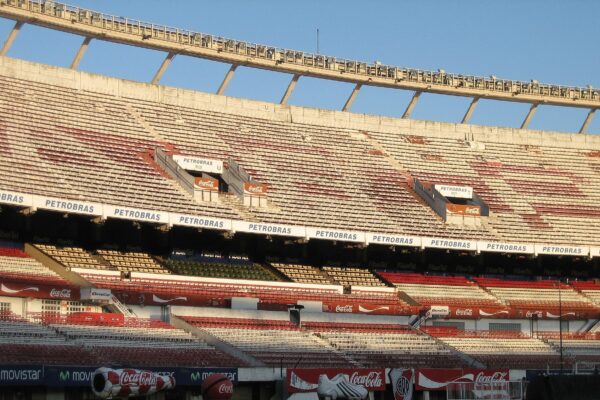 The upper and lower tiers of the stands at Estadio Monumental in Buenos Aires, with Petrobras and Coca-Cola advertising boards and a curved roof edge