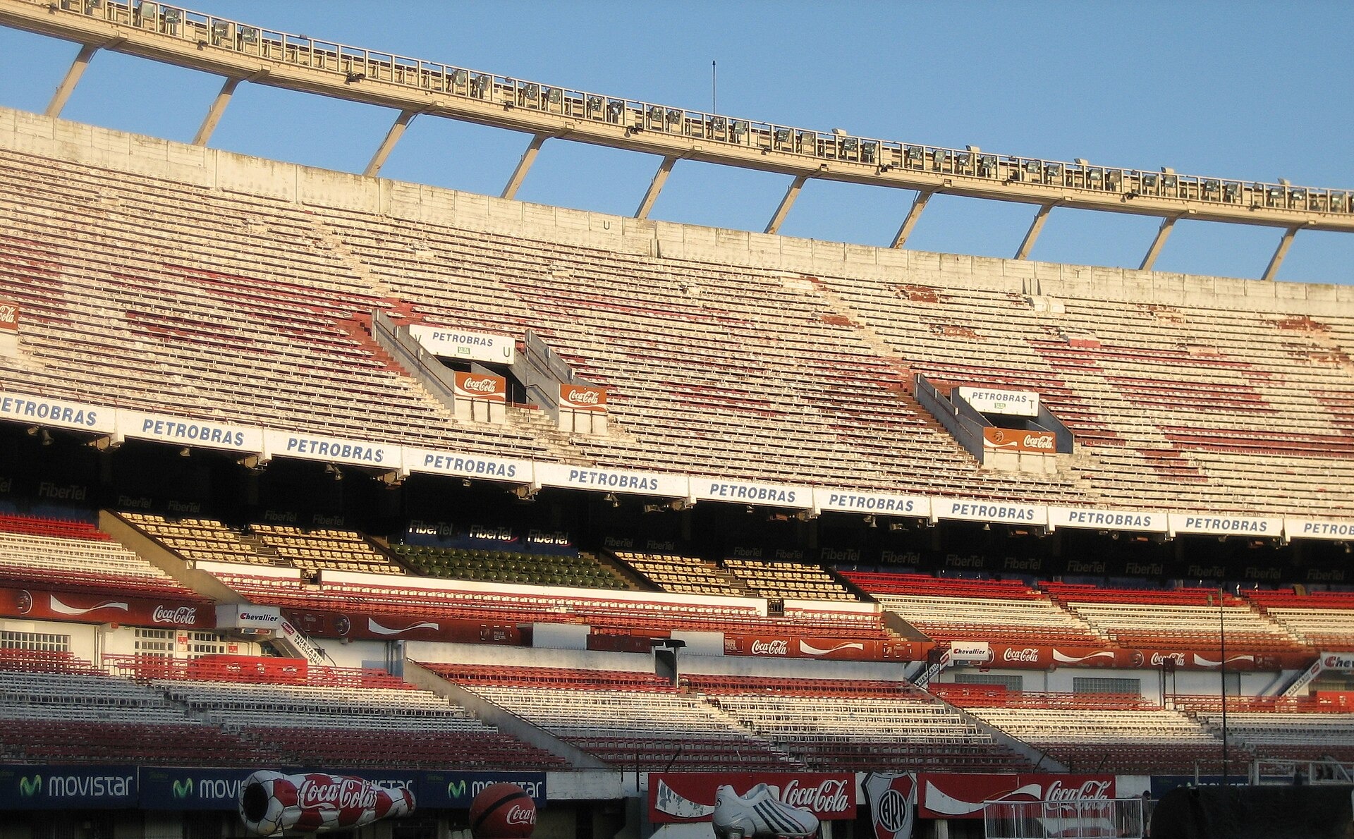 The upper and lower tiers of the stands at Estadio Monumental in Buenos Aires, with Petrobras and Coca-Cola advertising boards and a curved roof edge